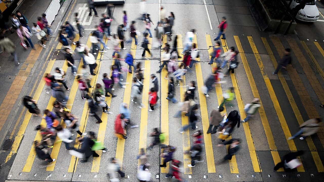 Personas cruzando una calle llena de gente en Hong Kong