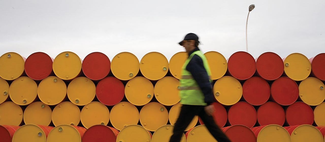 Hombre caminando cerca de barriles de lubricantes