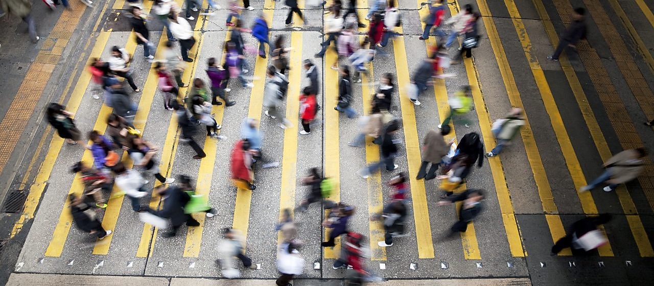 Personas cruzando una calle llena de gente en Hong Kong
