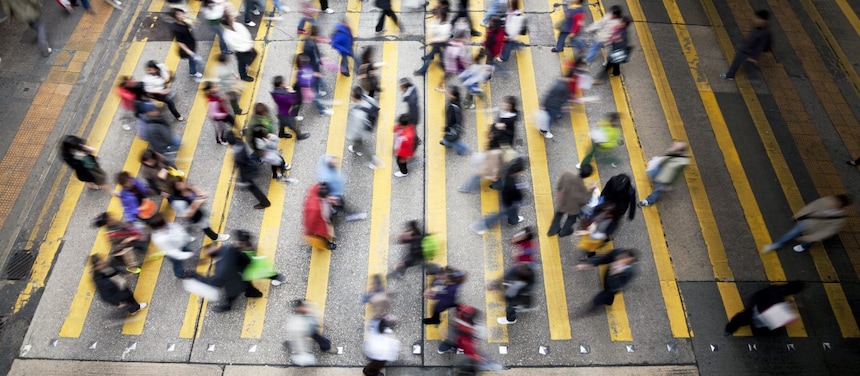 Personas cruzando una calle llena de gente en Hong Kong