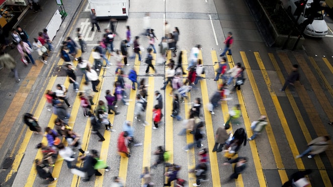 Personas cruzando una calle llena de gente en Hong Kong