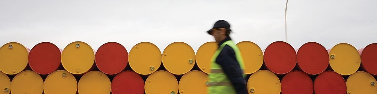 Hombre caminando cerca de barriles de lubricantes