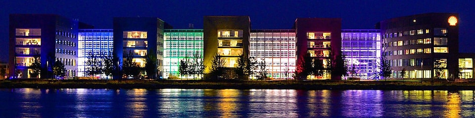 Un Conjunto de edificios de oficinas, reflejados en el agua por la noche