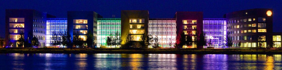 Conjunto de edificios de oficinas, reflejados en el agua por la noche