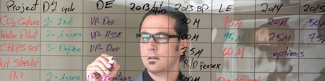 empleado escribiendo en una pizarra transparente.