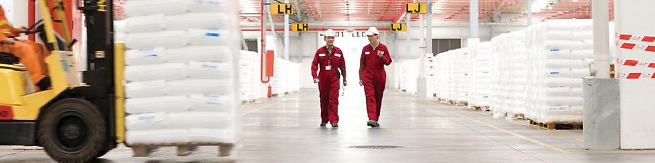 dos empleados andando por una fábrica