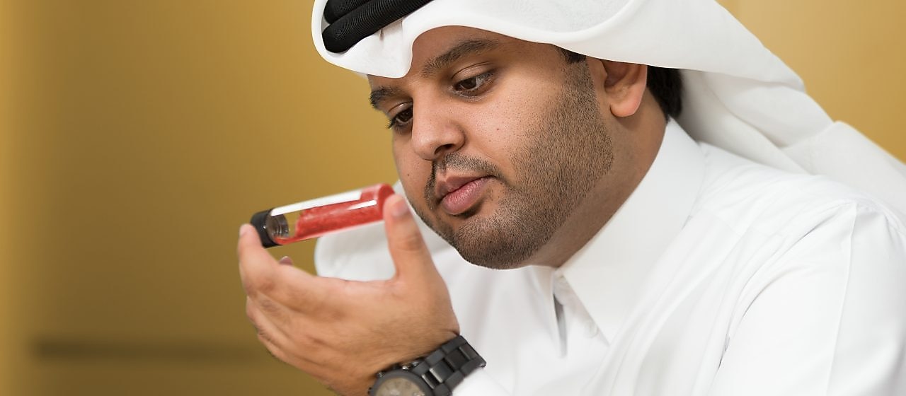 Mohammed Al Athba examina el contenido de un tubo de ensayos con tapa