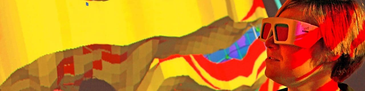 Una mujer con gafas especiales examina una proyección en 3D de un mapa geológico