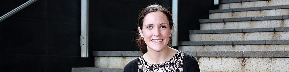 Siobhan Kelly sonríe delante de unas escaleras de hormigón