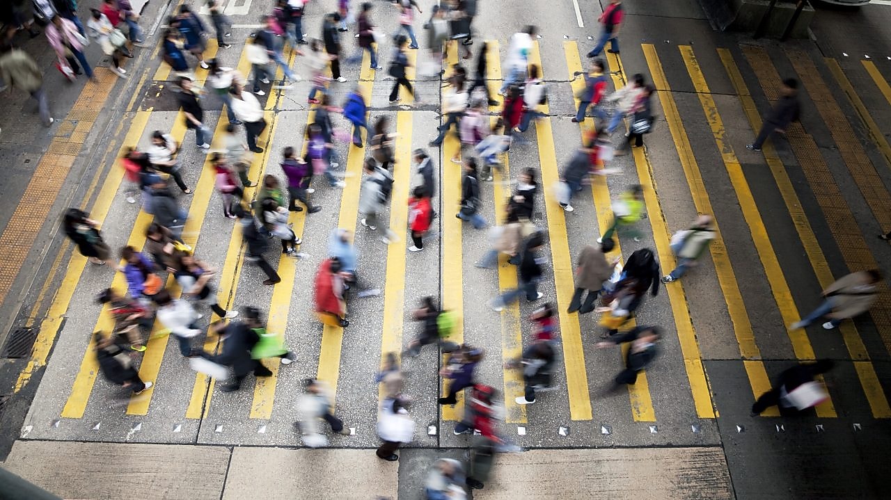 Personas cruzando una calle llena de gente en Hong&nbsp;Kong