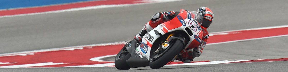 Ducati motorcycle racing around a corner of a racing track