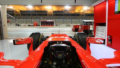 Ferrari dentro de un garaje cerca de una pista