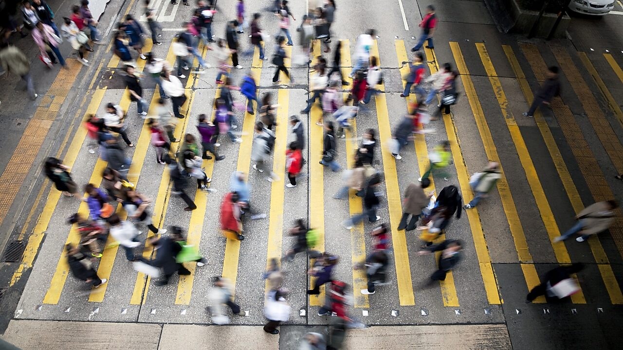 Personas cruzando una calle llena de gente en Honkong
