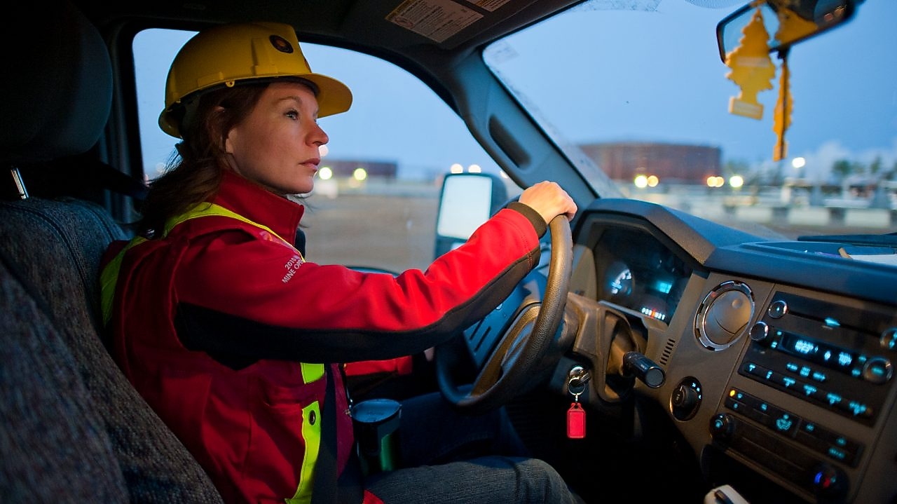 Señora con equipo de seguridad conduciendo un vehículo