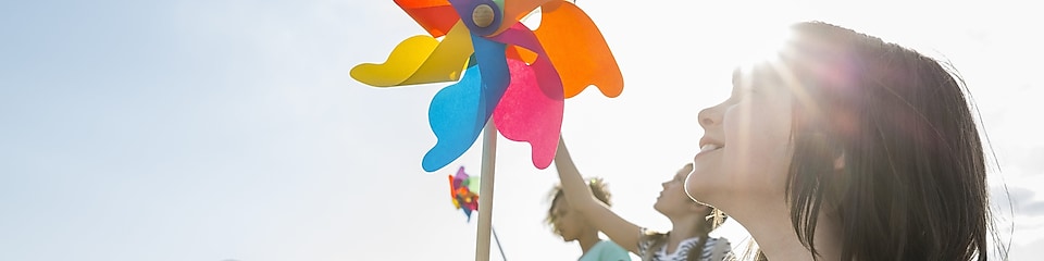 En la imagen, niñas juegan con un molino de viento.
