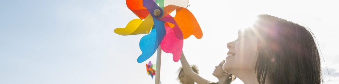 En la imagen, niñas juegan con un molino de viento.